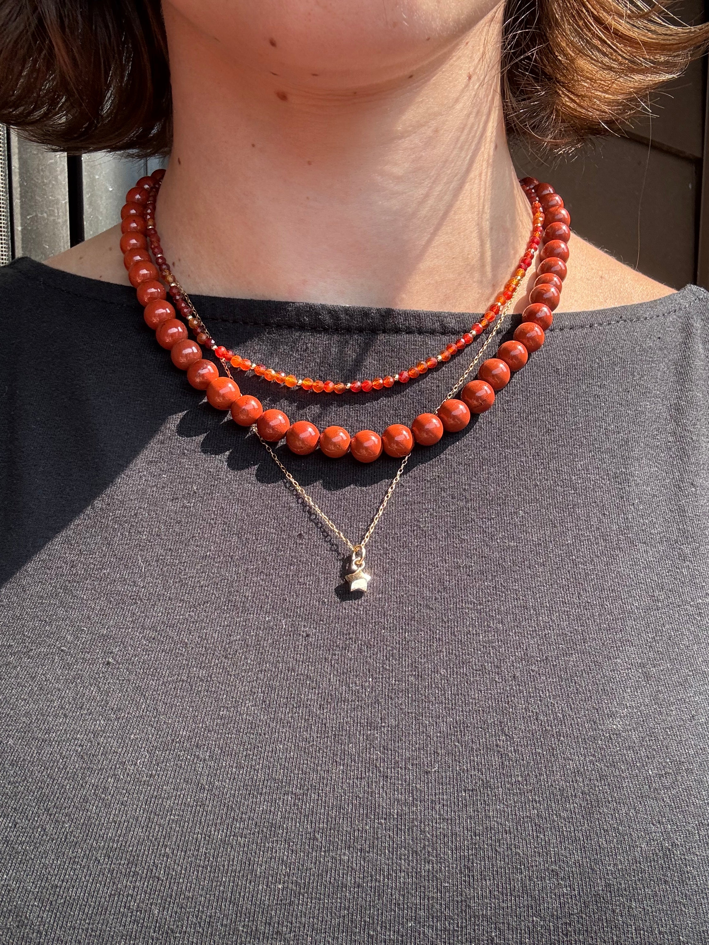 red jasper beaded gemstone necklace, carnelian agate gem necklace, and 14k gold filled star necklace on model