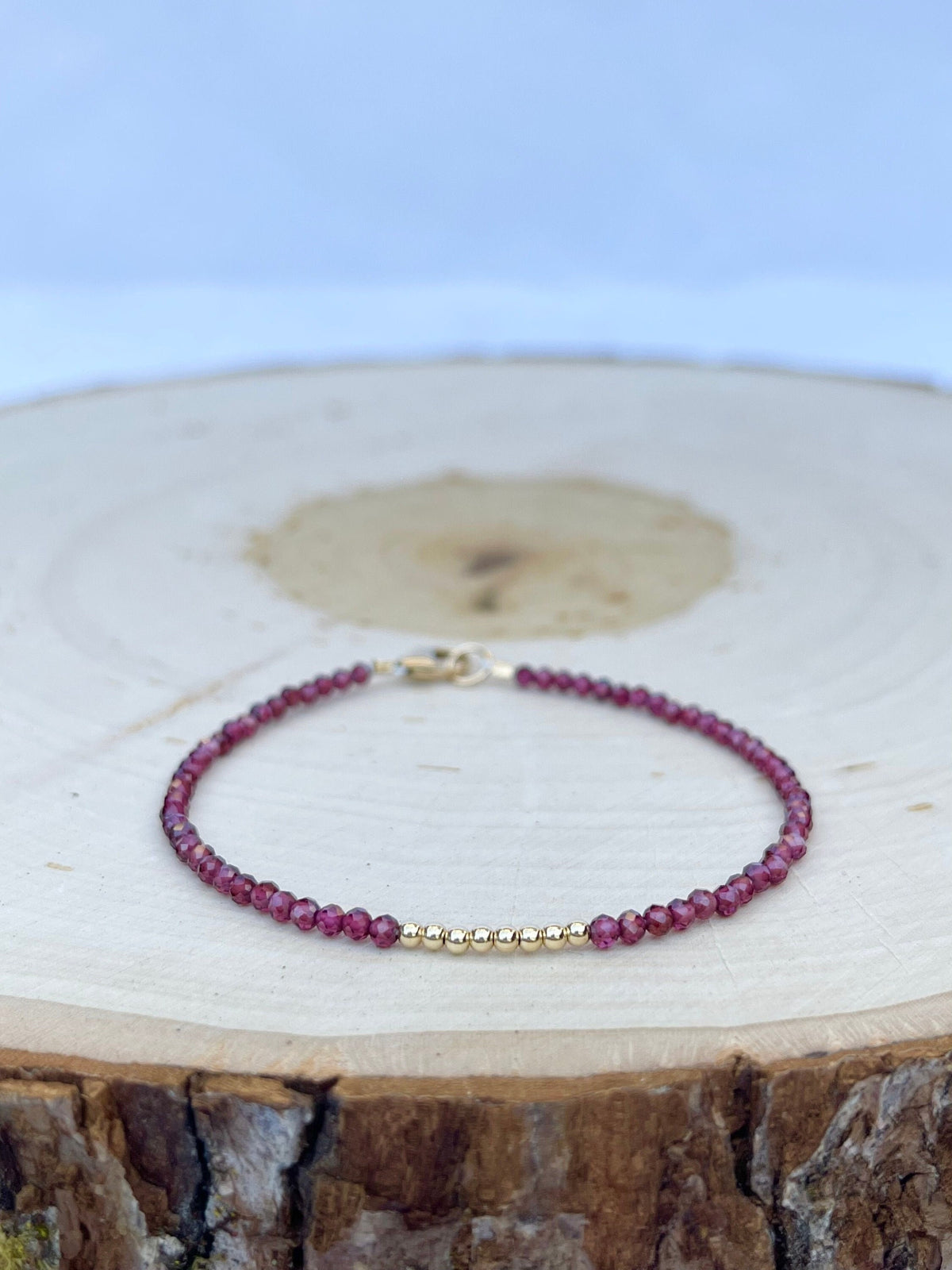handmade garnet gemstone birthstone bracelet, photo on wood background